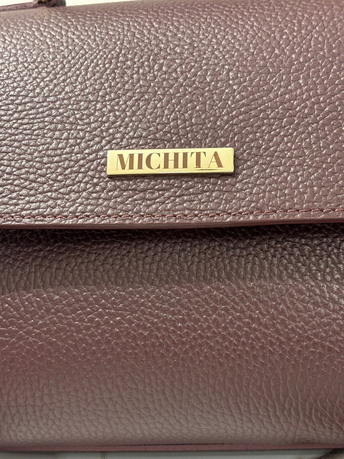 Dettaglio logo MICHITA in metallo dorato su Florence Bag in vera pelle Burgundy