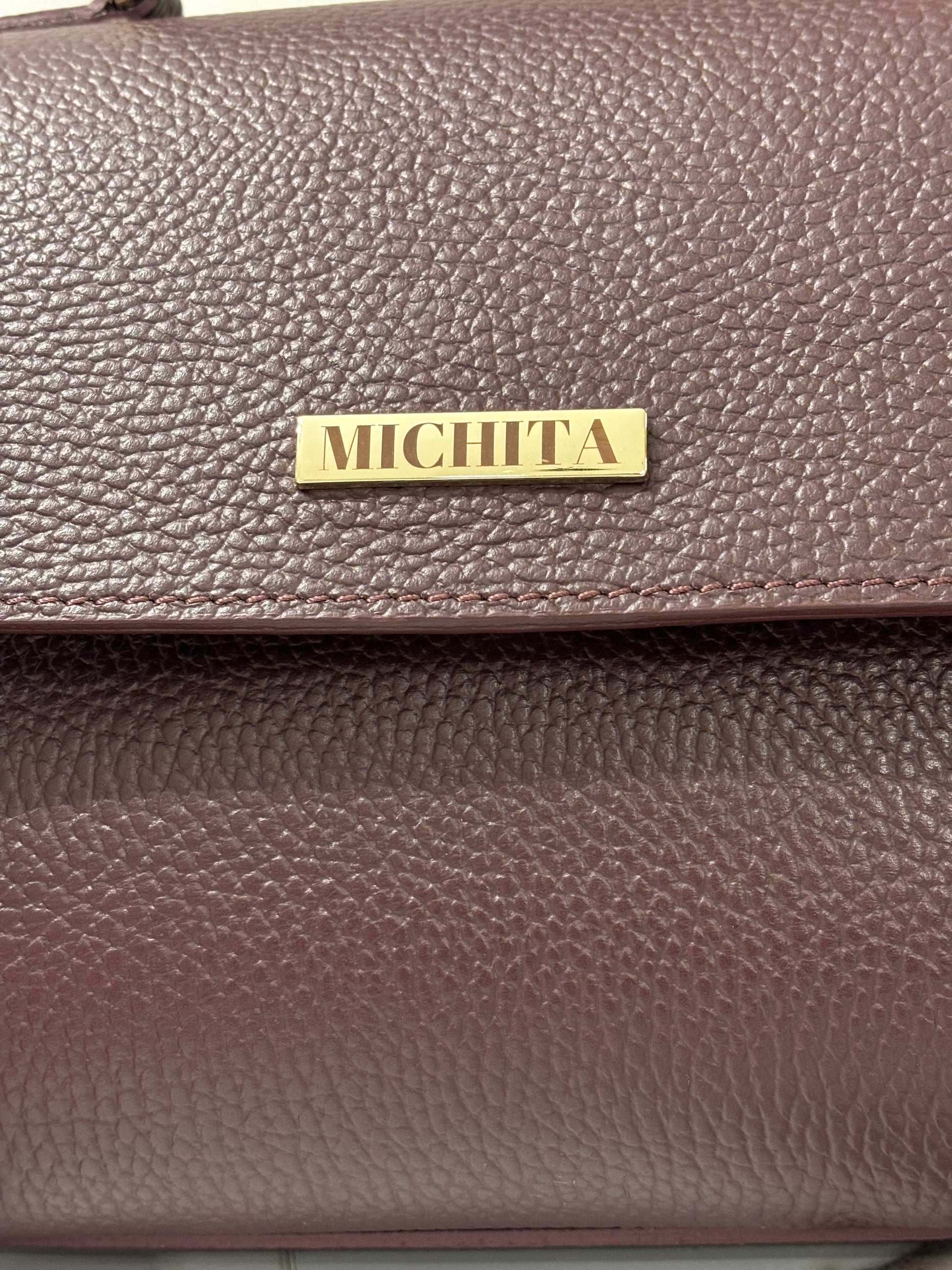 Dettaglio logo MICHITA in metallo dorato su Florence Bag in vera pelle Burgundy