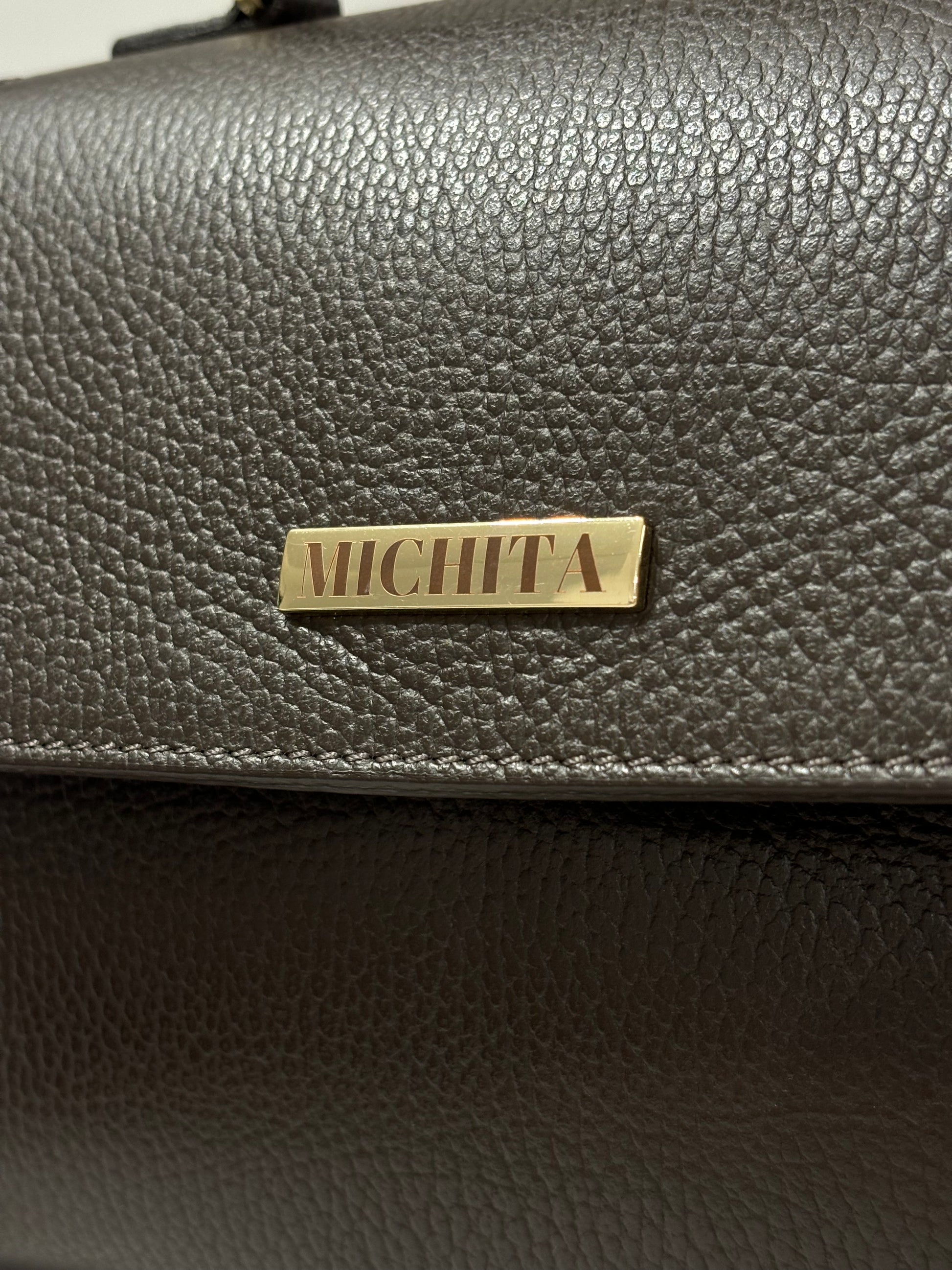 Dettaglio logo MICHITA in metallo dorato su Florence Bag in vera pelle Dark Chocolate